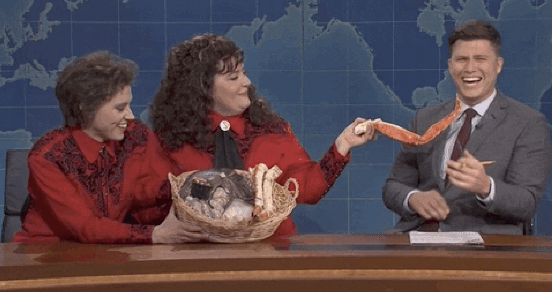 Cast members of SNL during the &quot;Weekend Update&quot; segment, with one holding up a crab leg