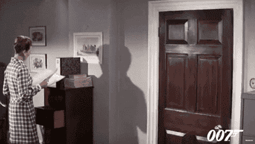 GIF of actor Sean Connery tossing his hat onto a coat rack in the movie &quot;On Her Majesty&#x27;s Secret Service&quot;
