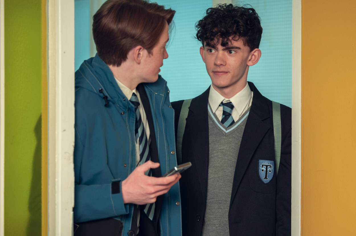 Charlie and Nick walk into each other as they enter a door at school and they exchange a look of warmth
