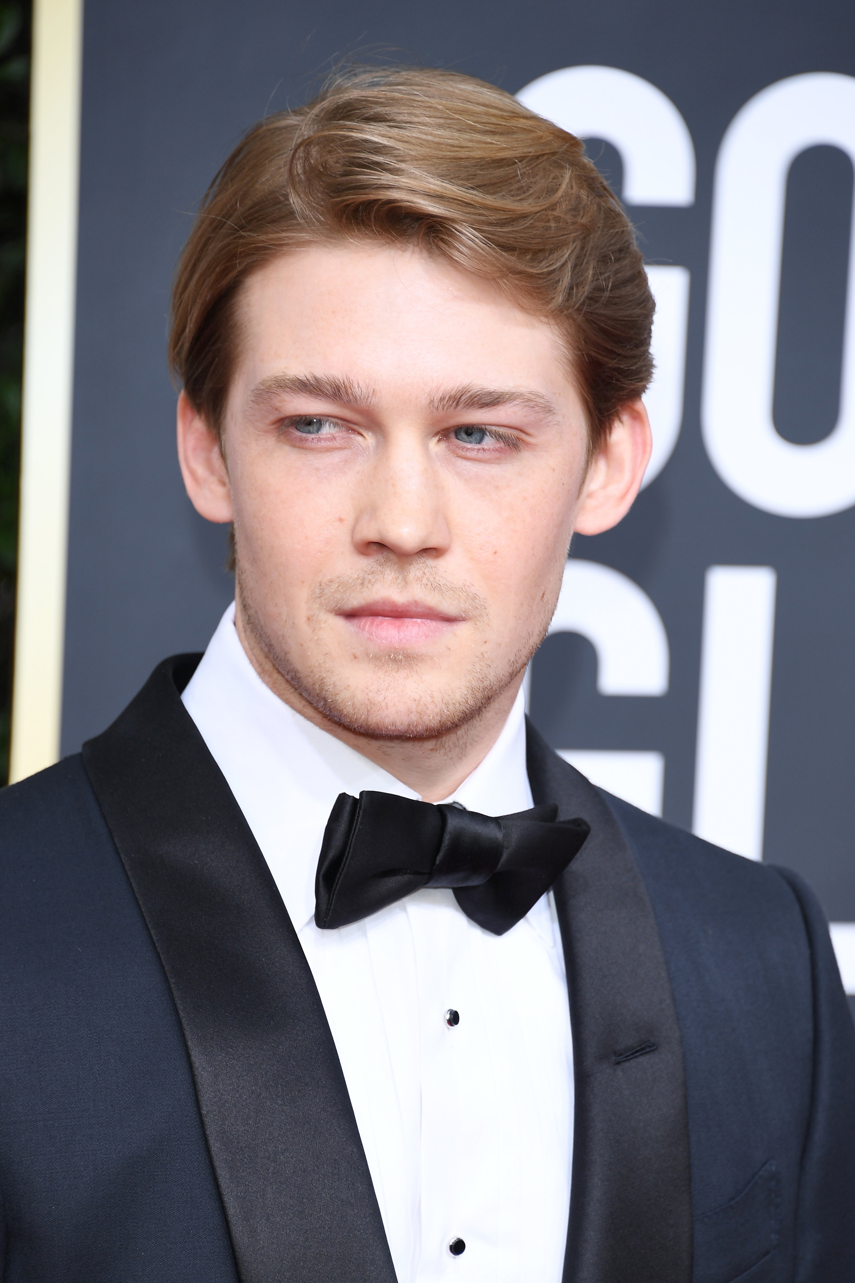 Joe poses on the red carpet while wearing a tuxedo