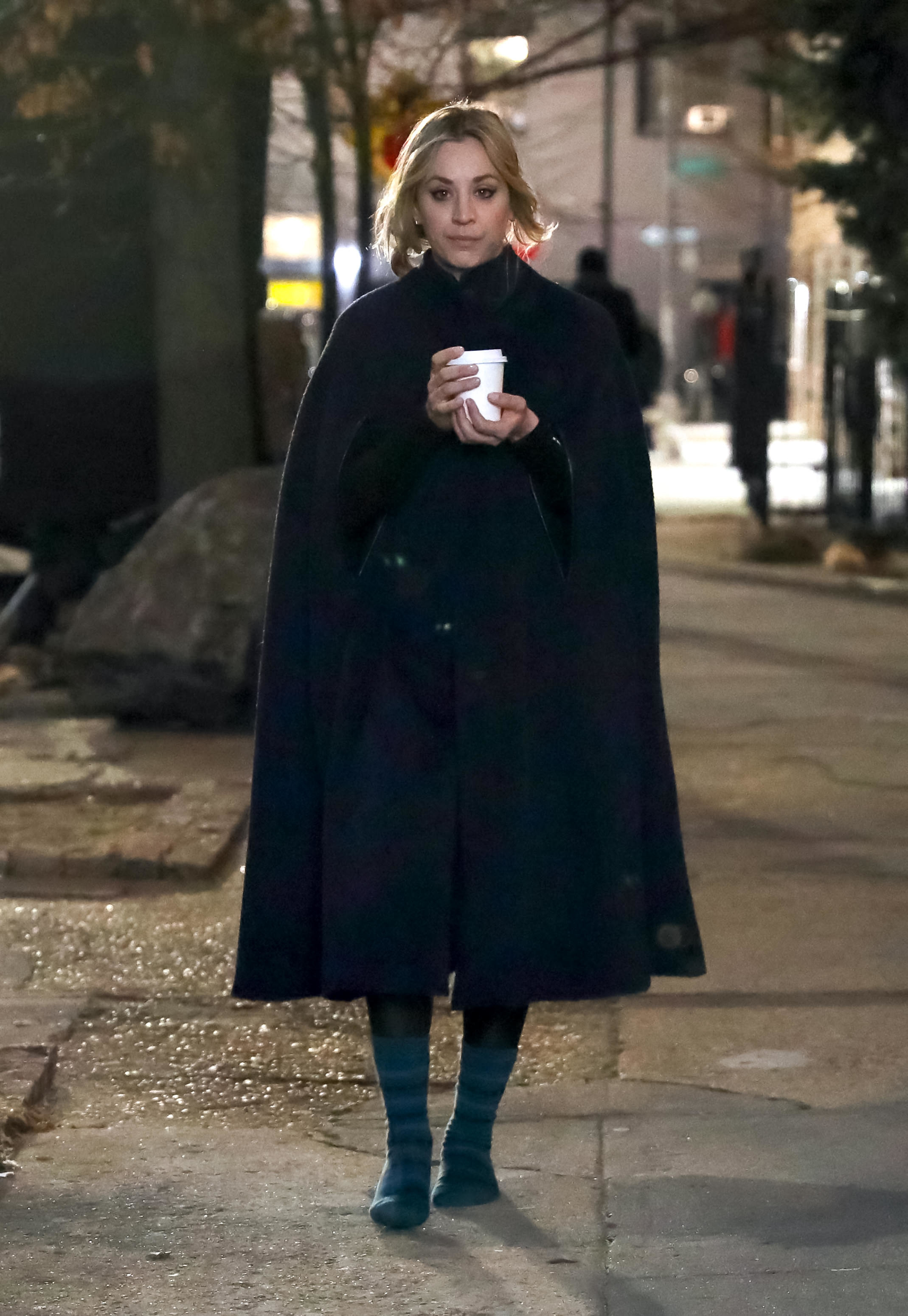 Kaley walks down the street with a hot beverage