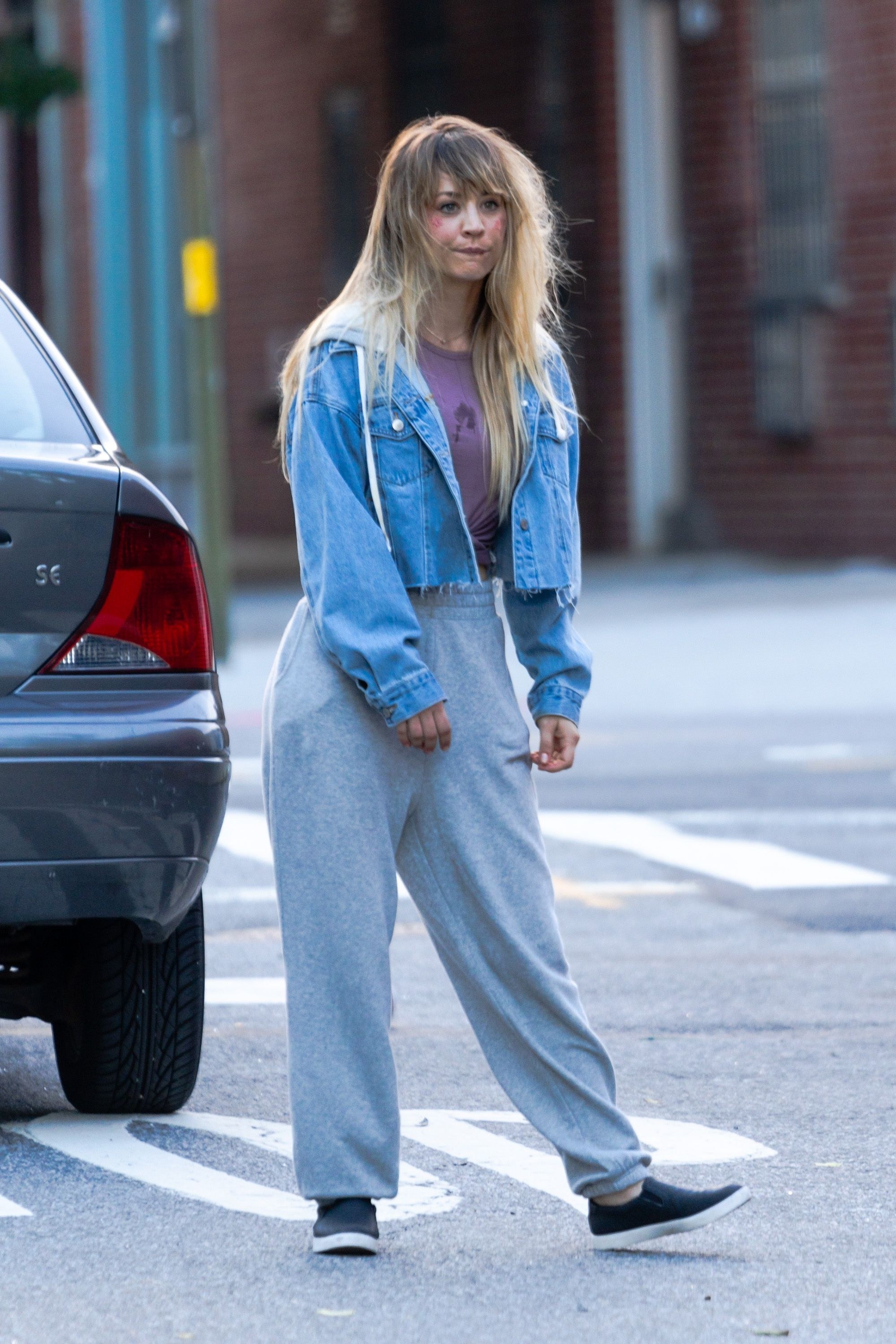 Kaley walks down the street in sweatpants and a jean jacket