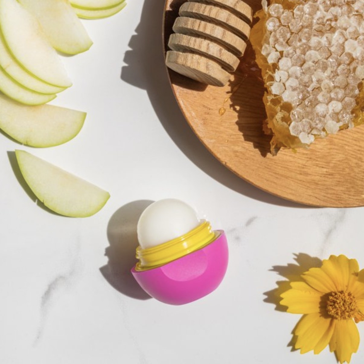 A lip balm sphere with sliced apples and flower buds