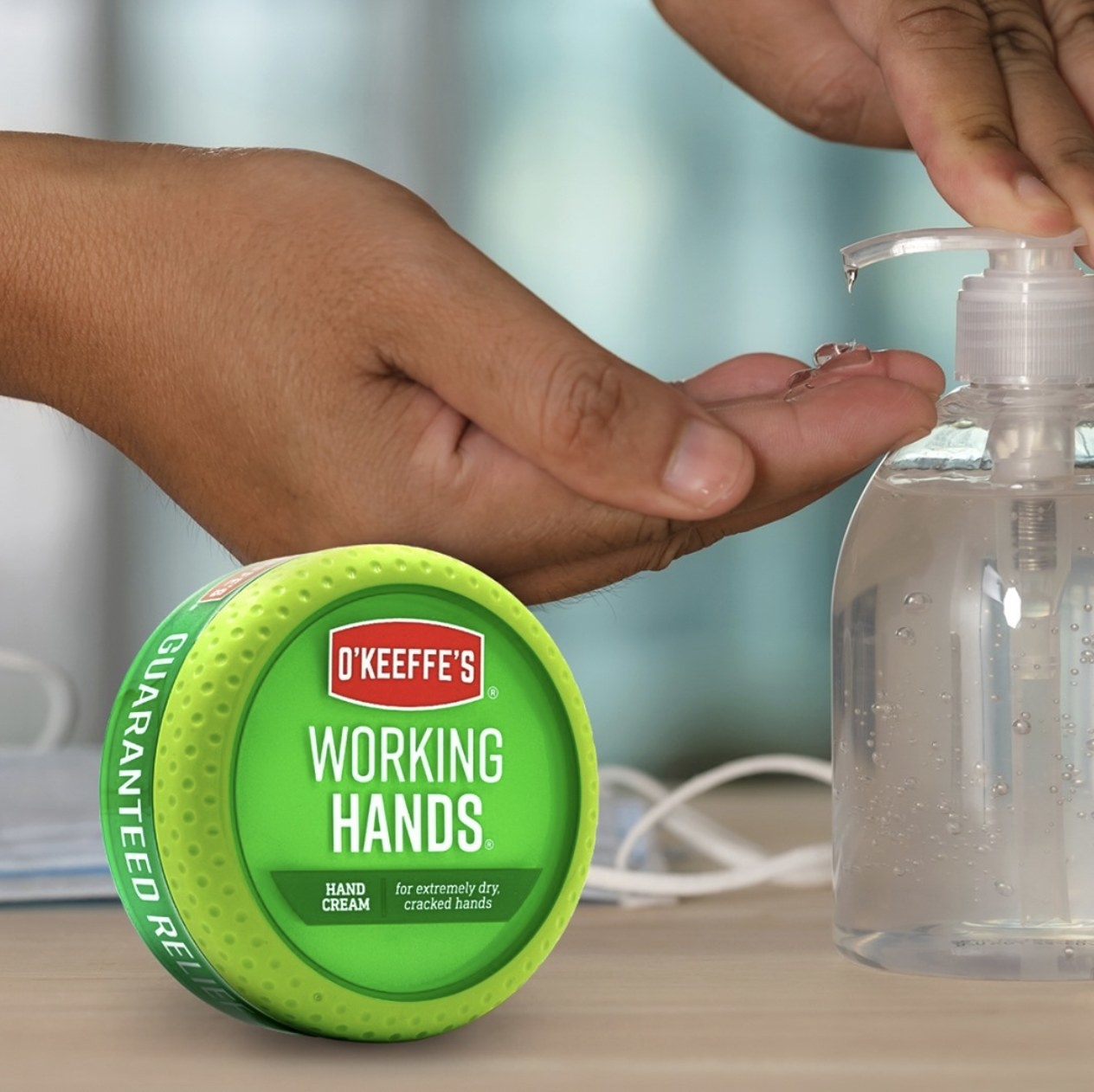 A person pumping hand sanitizer with a jar of hand cream.