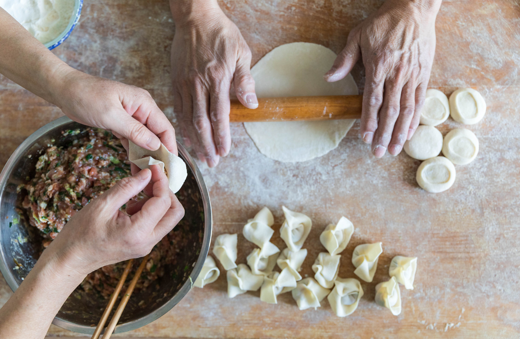 Hands making dumplings.