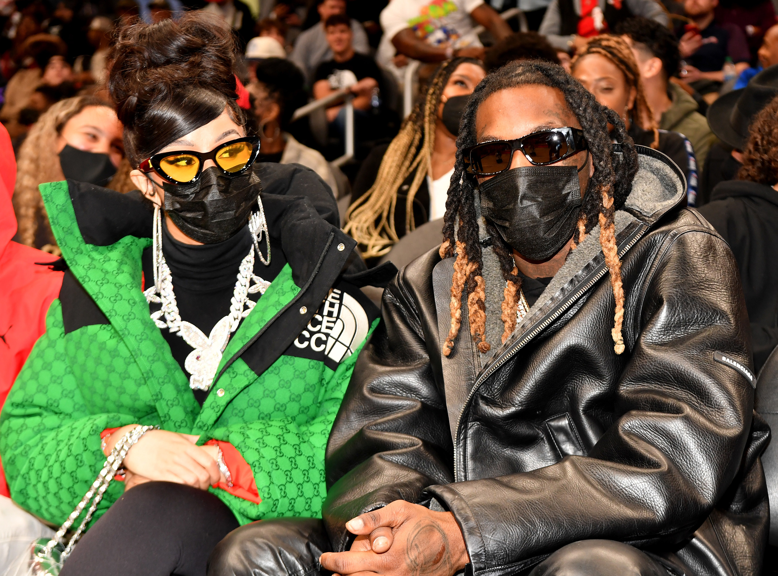 Cardi B and Offset sitting side by side in a stadium