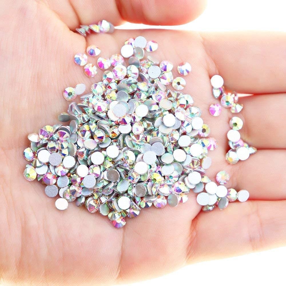 A person holding the tiny crystals in the palm of their hand