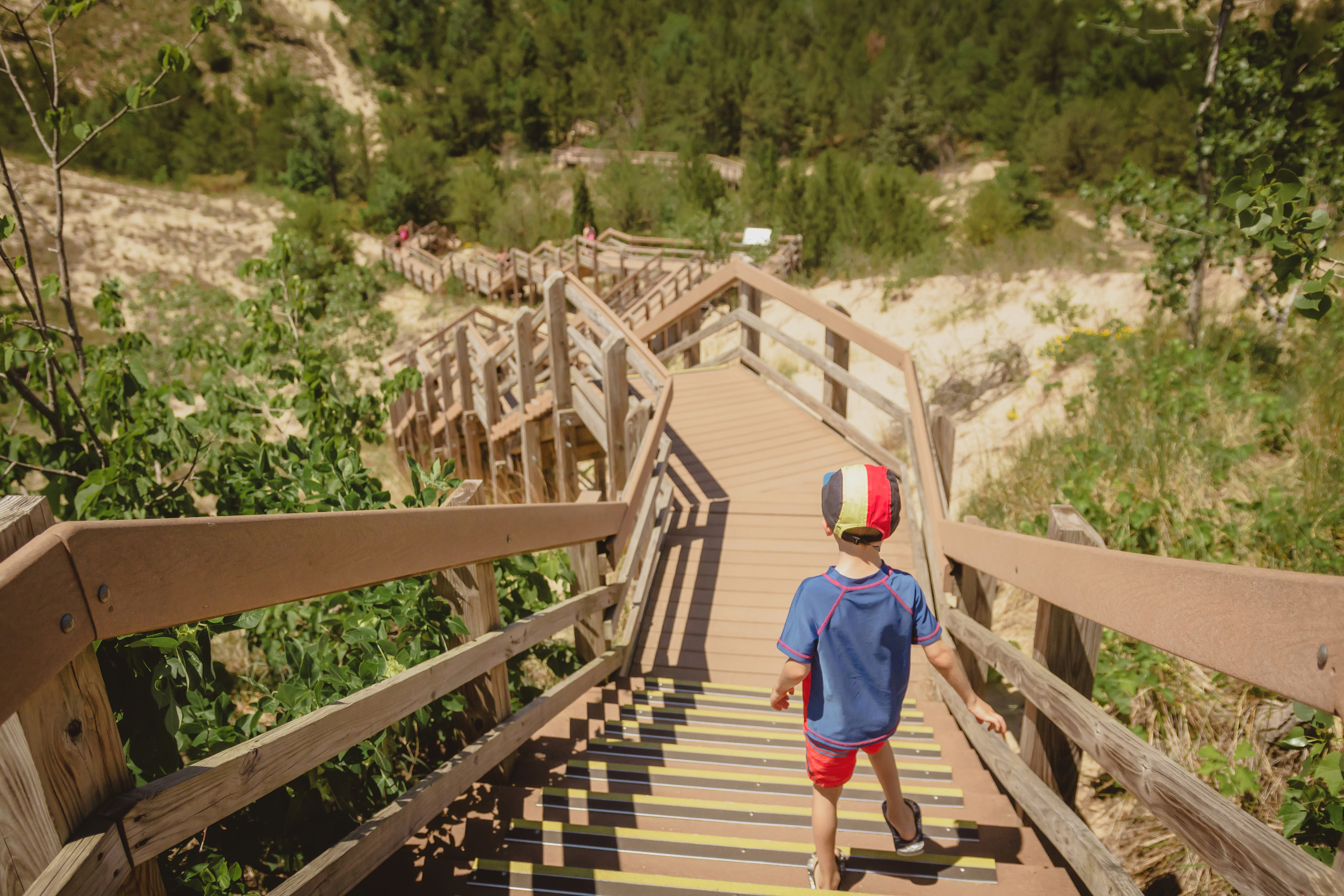 Young boy walks a staircase toward the forest
