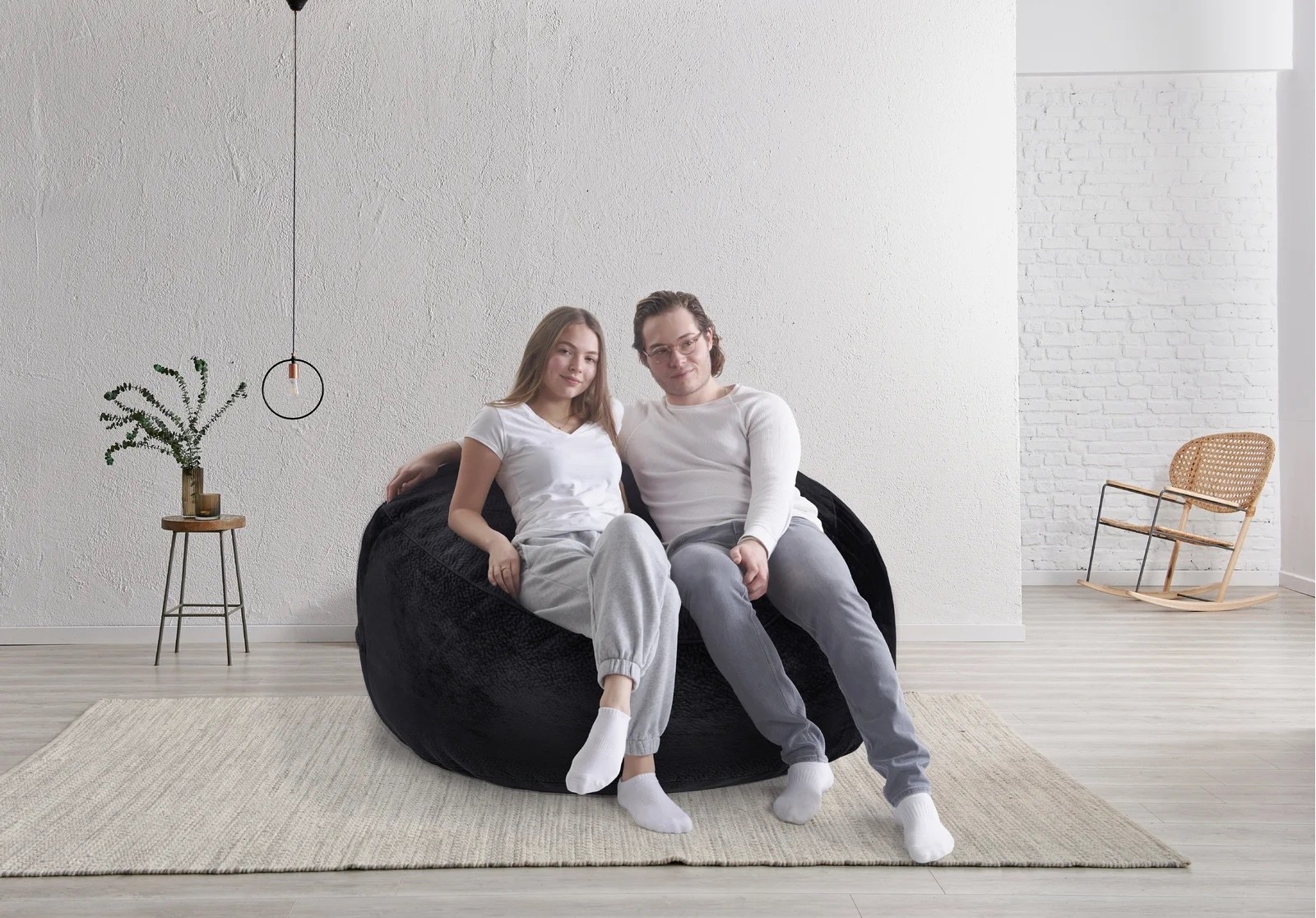 A pair of people sitting on a beanbag chair in the middle of a room