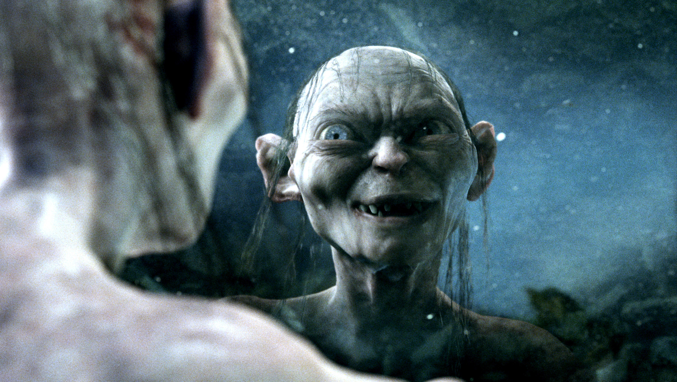 Gollum looking at his reflection in a pool of water