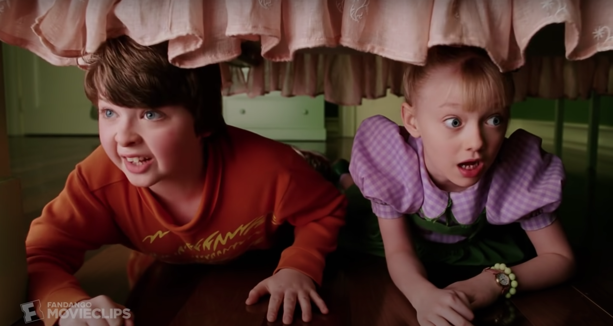 Two kids hiding under the bed from the cat in the hat