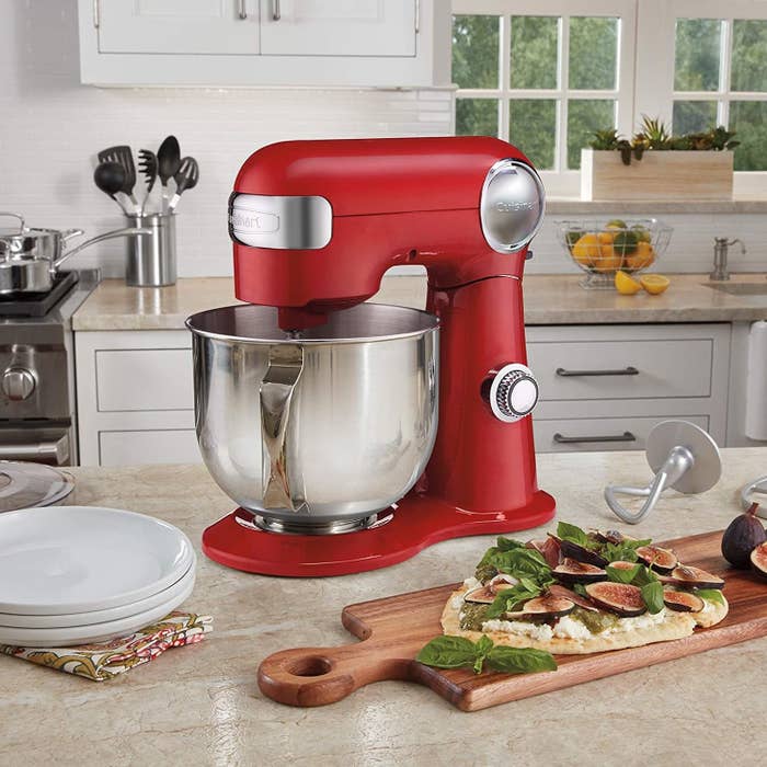 The stand mixer on a kitchen counter surrounded by pizza