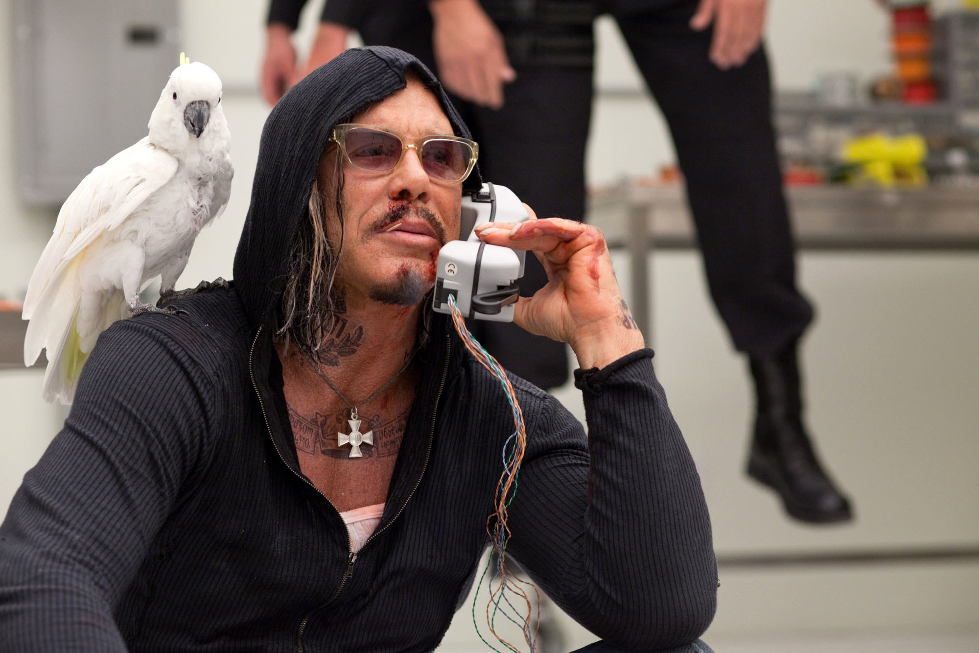 Mickey Rourke with a bird on his shoulder while talking on the phone.