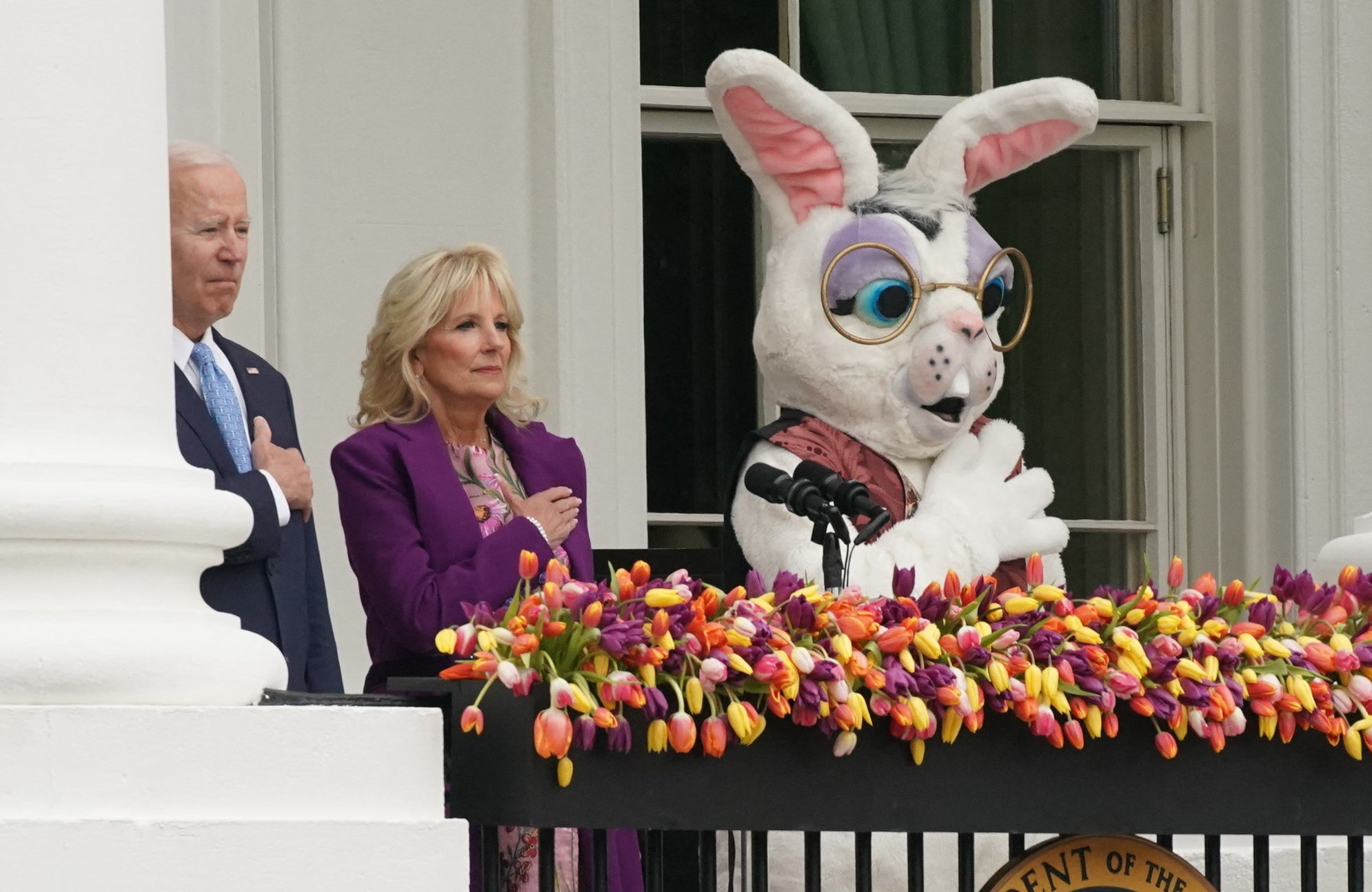 The shocked bunny in purple eyeshadow stand next to the Bidens, all with their hands on their hearts