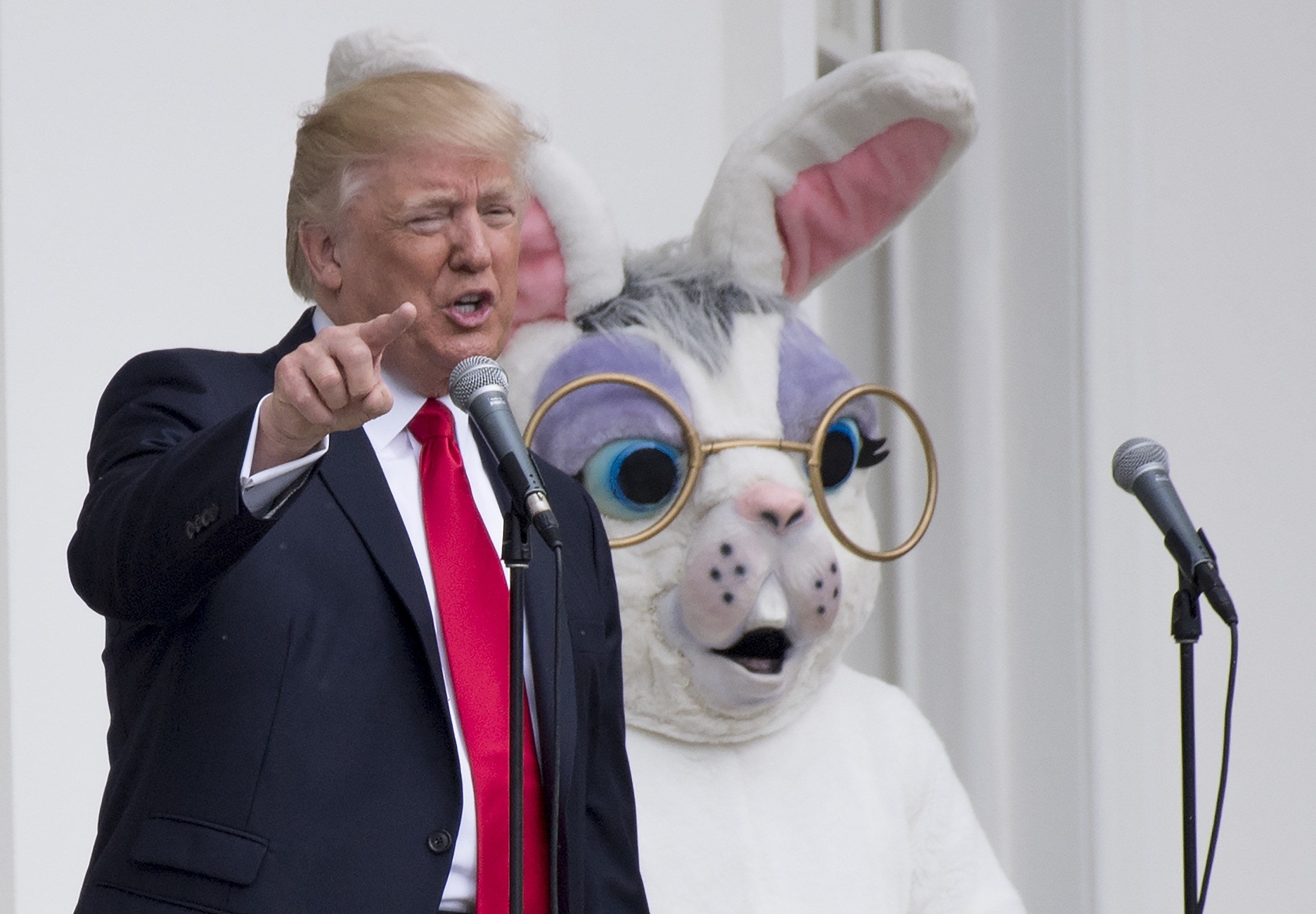 Trump points and speaks as the shocked Easter bunny looks on