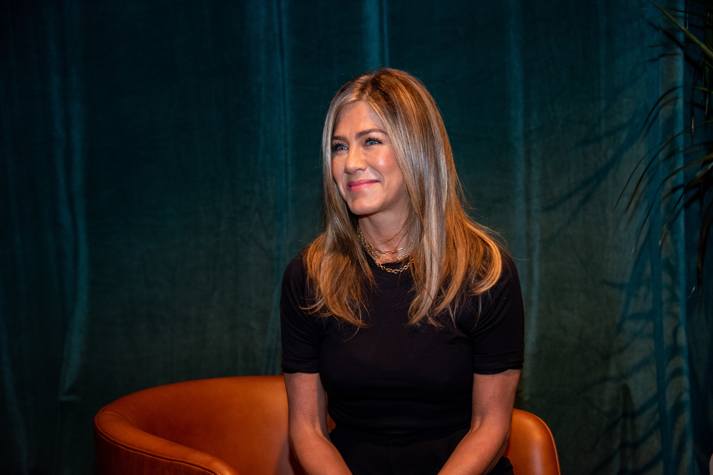 Jennifer smiles while sitting in a chair