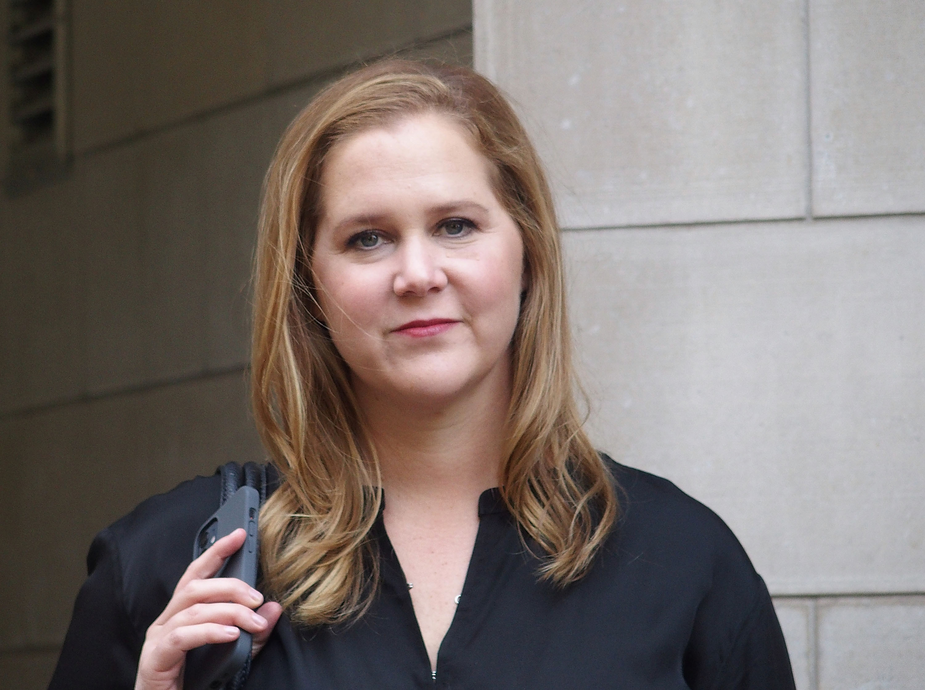 Amy Schumer holding her cellphone.