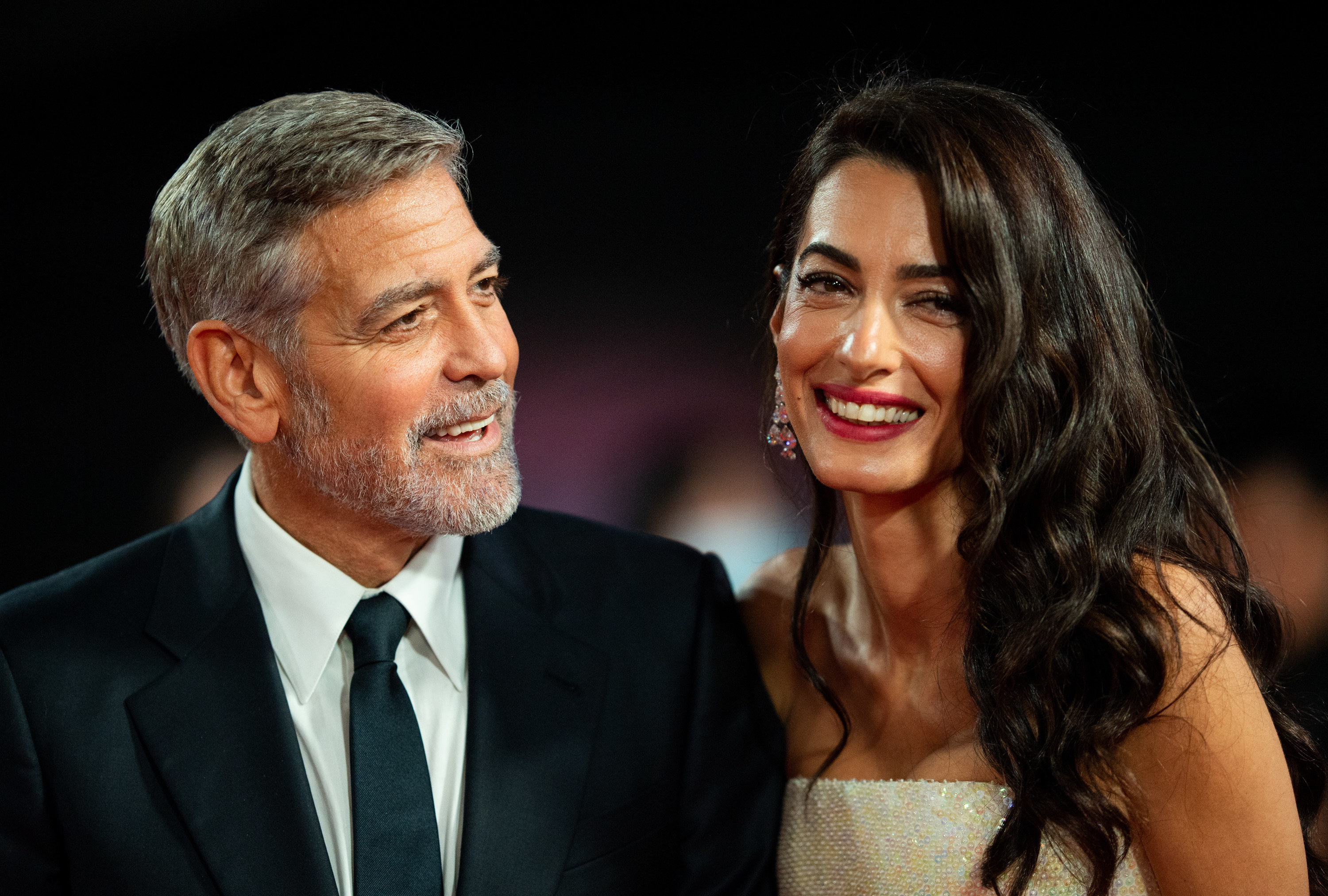 George and Amal Clooney laughing together at an event