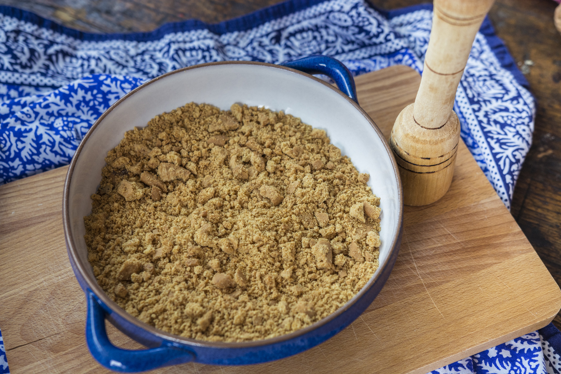 Forming a Graham cracker crust in a pie dish.