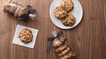 A gif of someone breaking apart a cookie, with the stack of four cookies packaged in cellophane with a bow