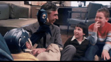 Rogers showing a puppet to young children
