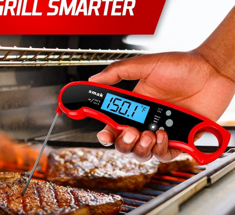 the digital thermometer telling the temperature of a steak on a grill
