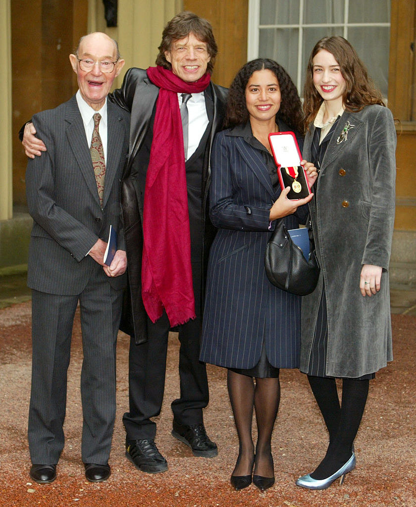 Mick Jagger posing for a photograph with others.