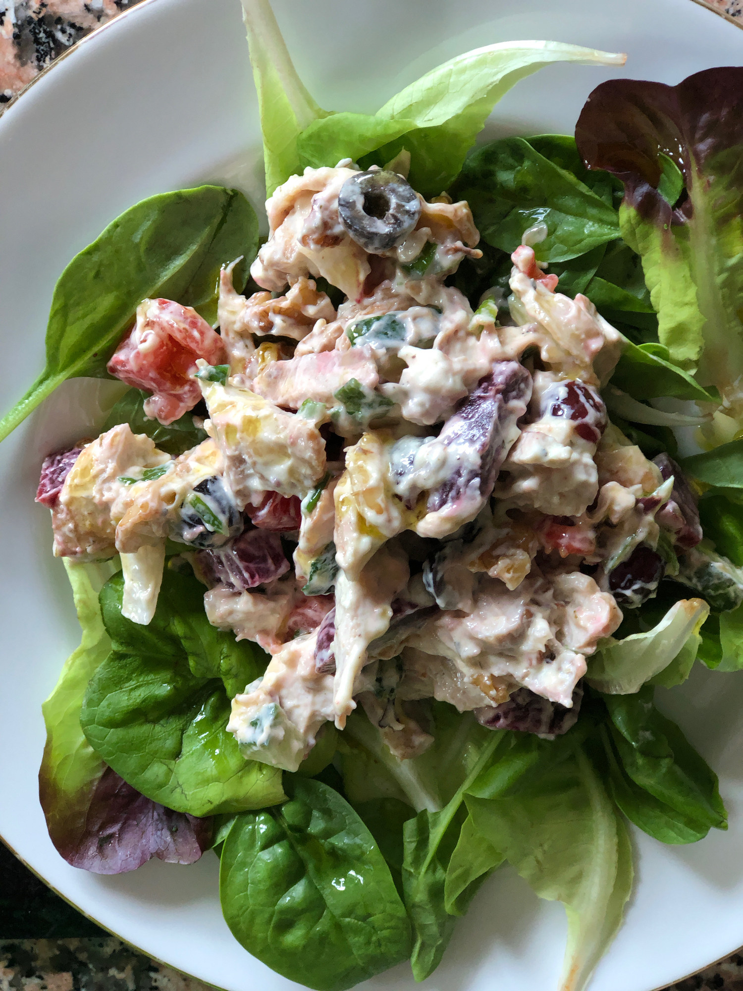 Chicken salad on a bed of spinach.