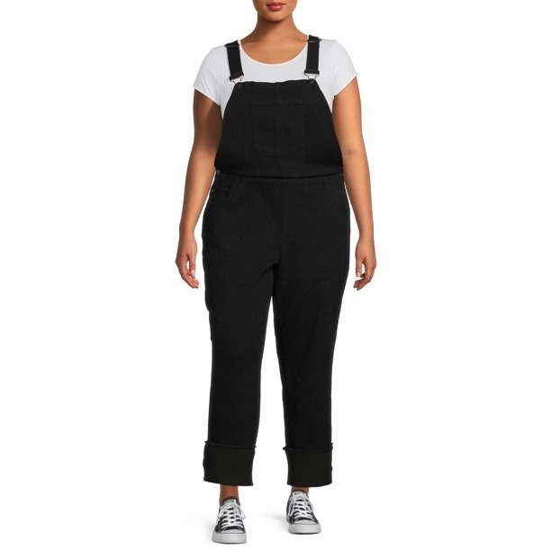 Model wearing black overalls with white shoe and black shoes
