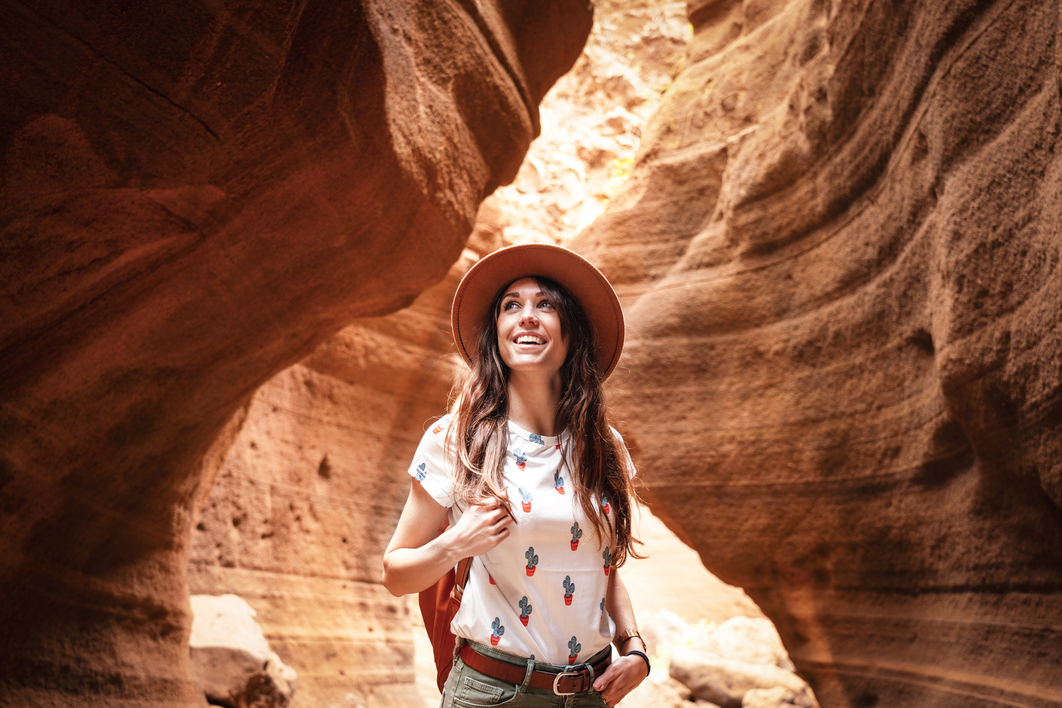 a woman smiling while in a desert canyon
