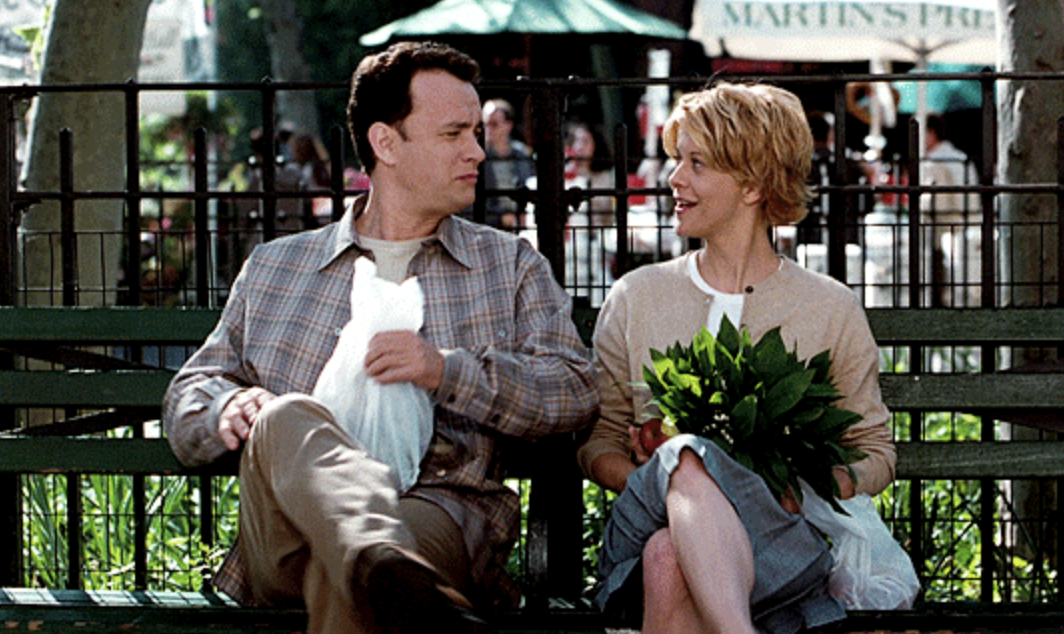 Tom Hanks and Meg Ryan sitting on a park bench and talking