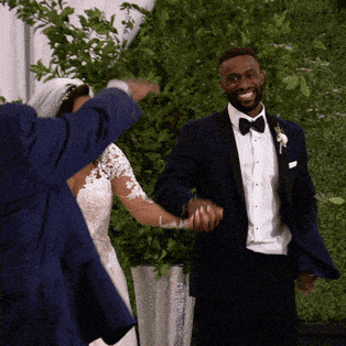 A bride and groom dancing toward their reception.