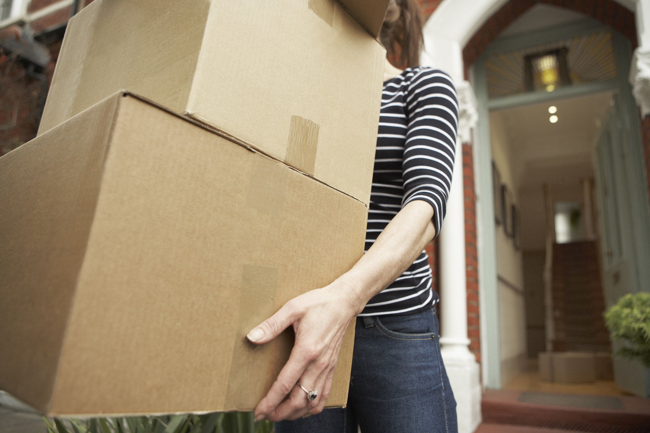 A woman holding moving boxes.