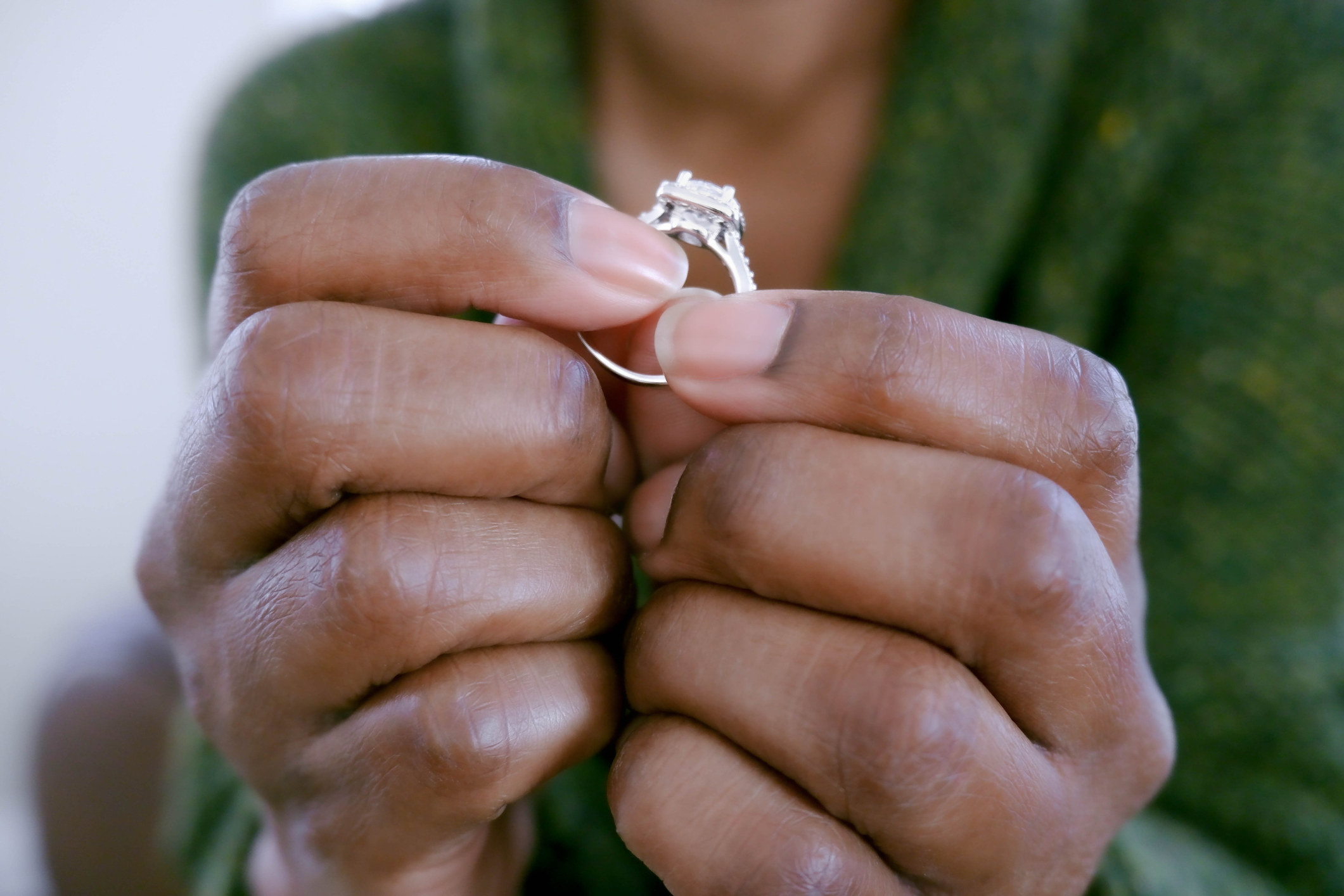 A woman holding an engagement ring.