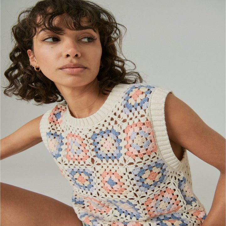 a model in crochet blue, orange, and white sweater tank