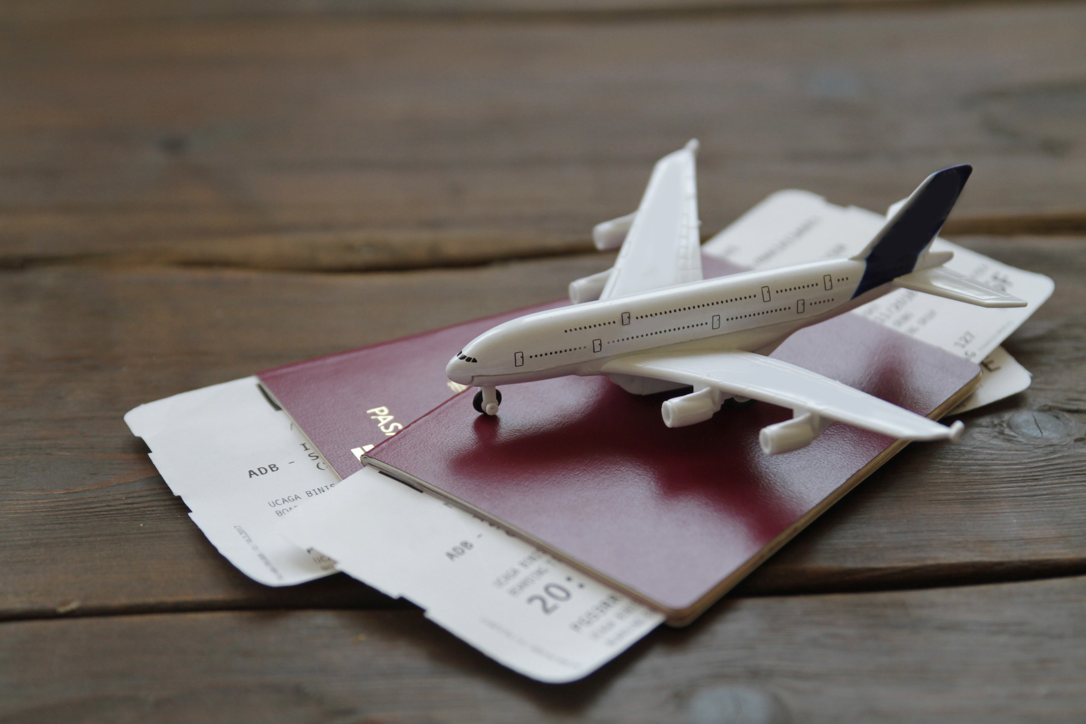 A toy airplane set atop passports and boarding passes.
