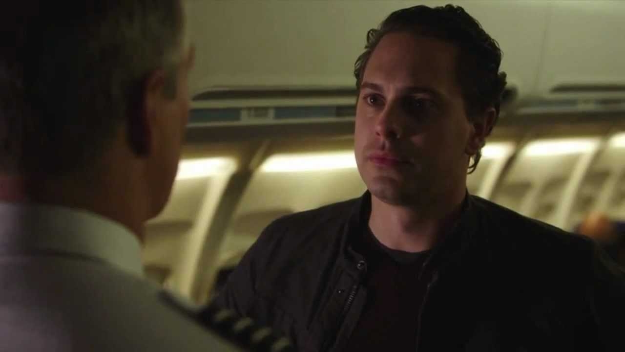 A man stands on a plane and looks somber as he looks at the pilot