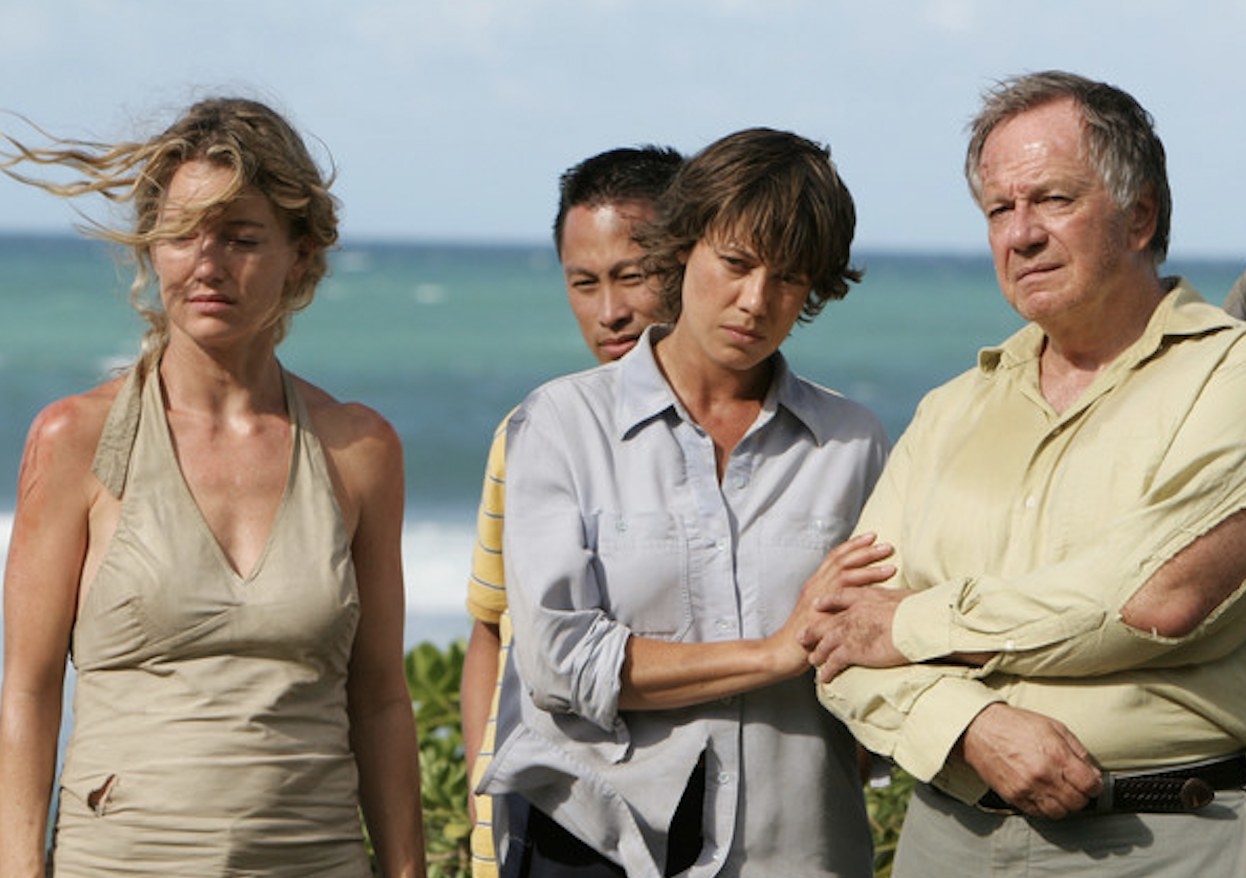Two women and two men stand near the beach; they are dirty and disheveled