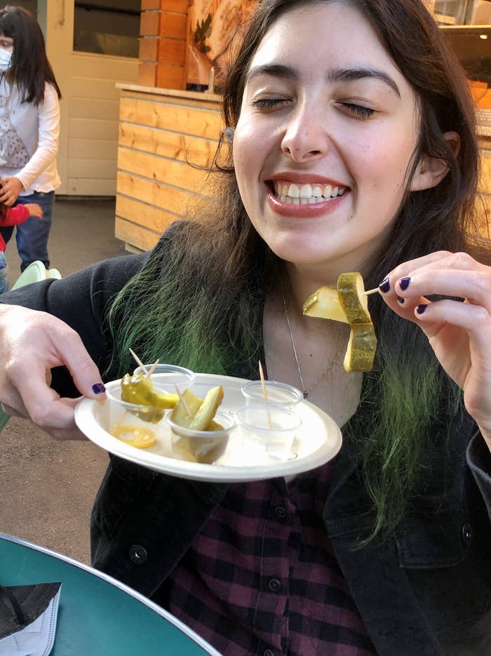 Woman smiling land holding a plate of pickles