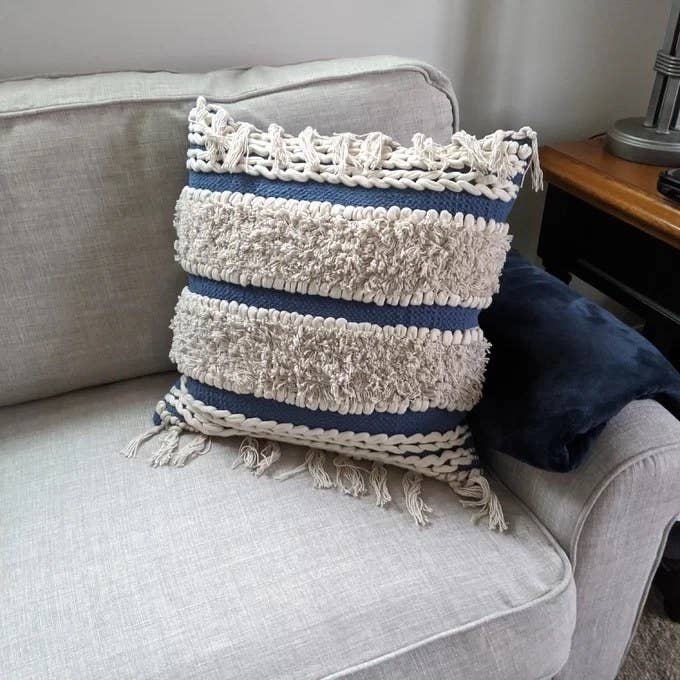the blue and tan throw pillow on a couch