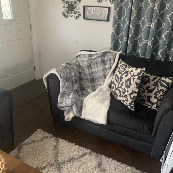 Gray lattice printed throw blanket on a black couch