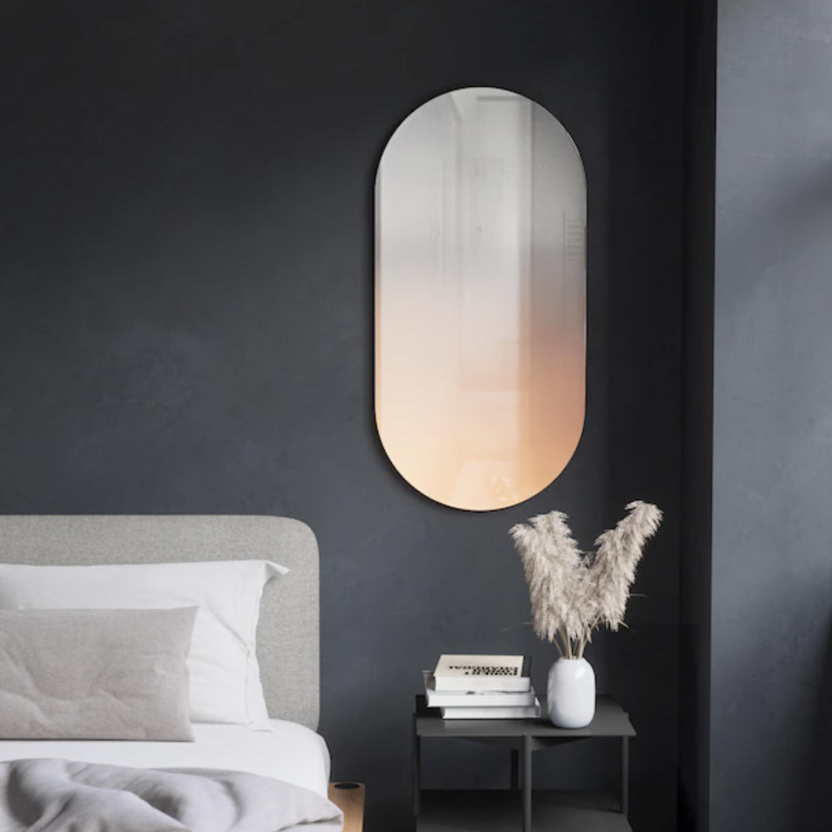 the ombre oval mirror mounted on a wall