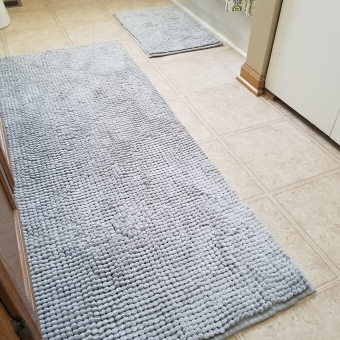 a reviewer photo of the light blue bath mat