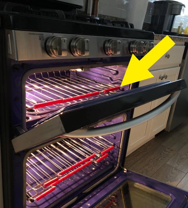 a reviewer's open oven with red guard installed on the racks 