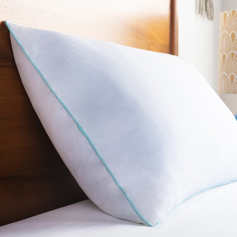 the white pillow with blue piping