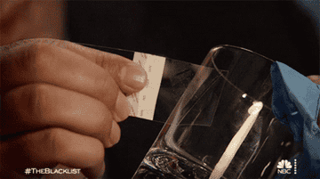 an agent getting a fingerprint from a glass and analyzing it