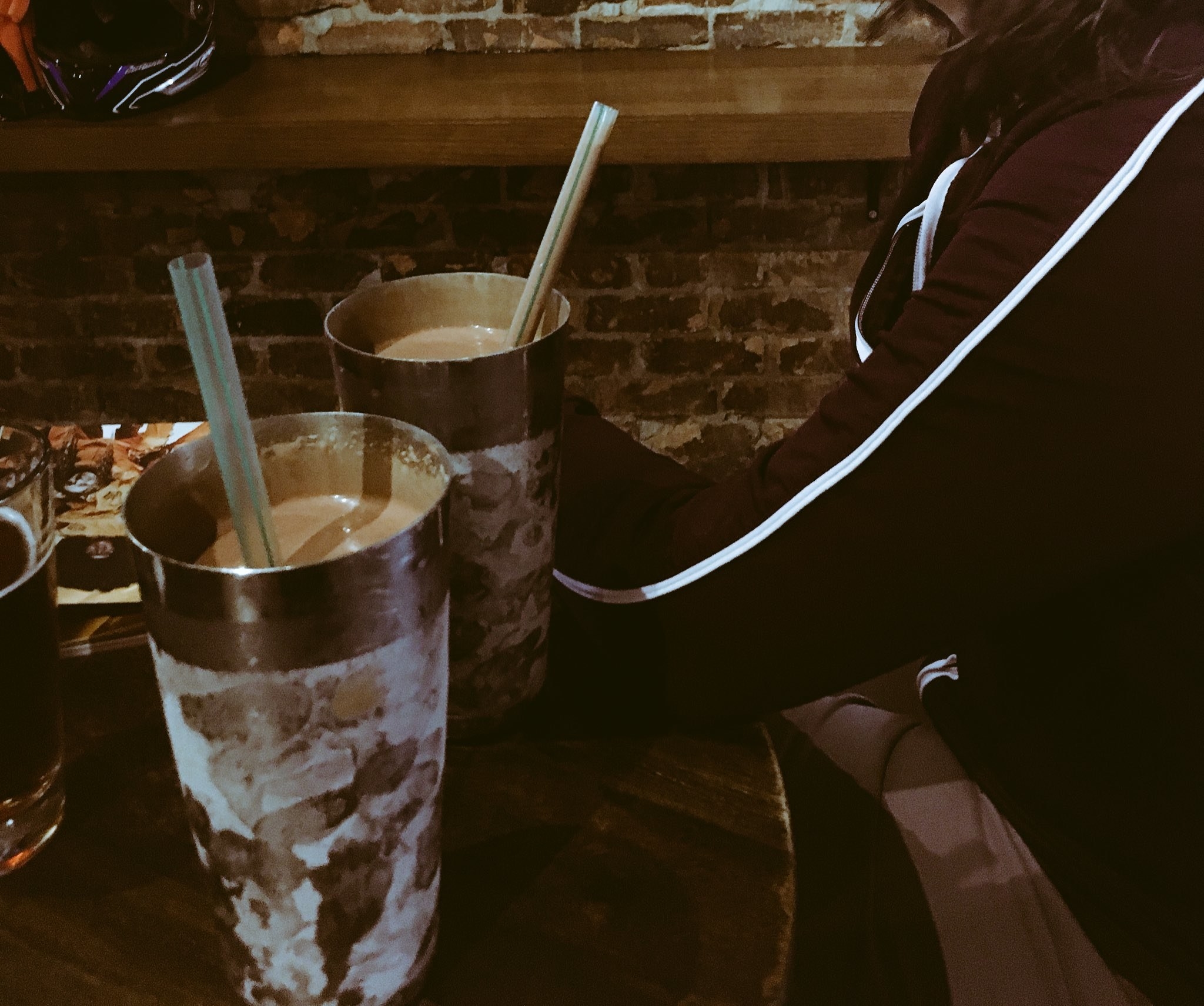 Several large cups of thickshakes with straws on a table