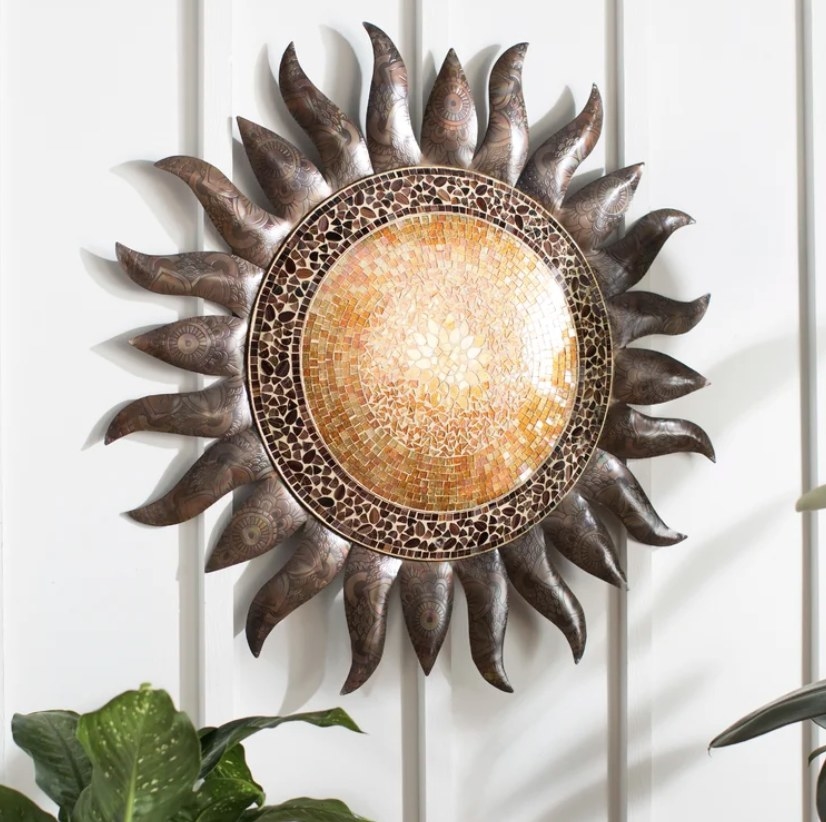 The sun wall art has a golden orange inner circle, a dark brown outer edge and darker rays coming out from all around