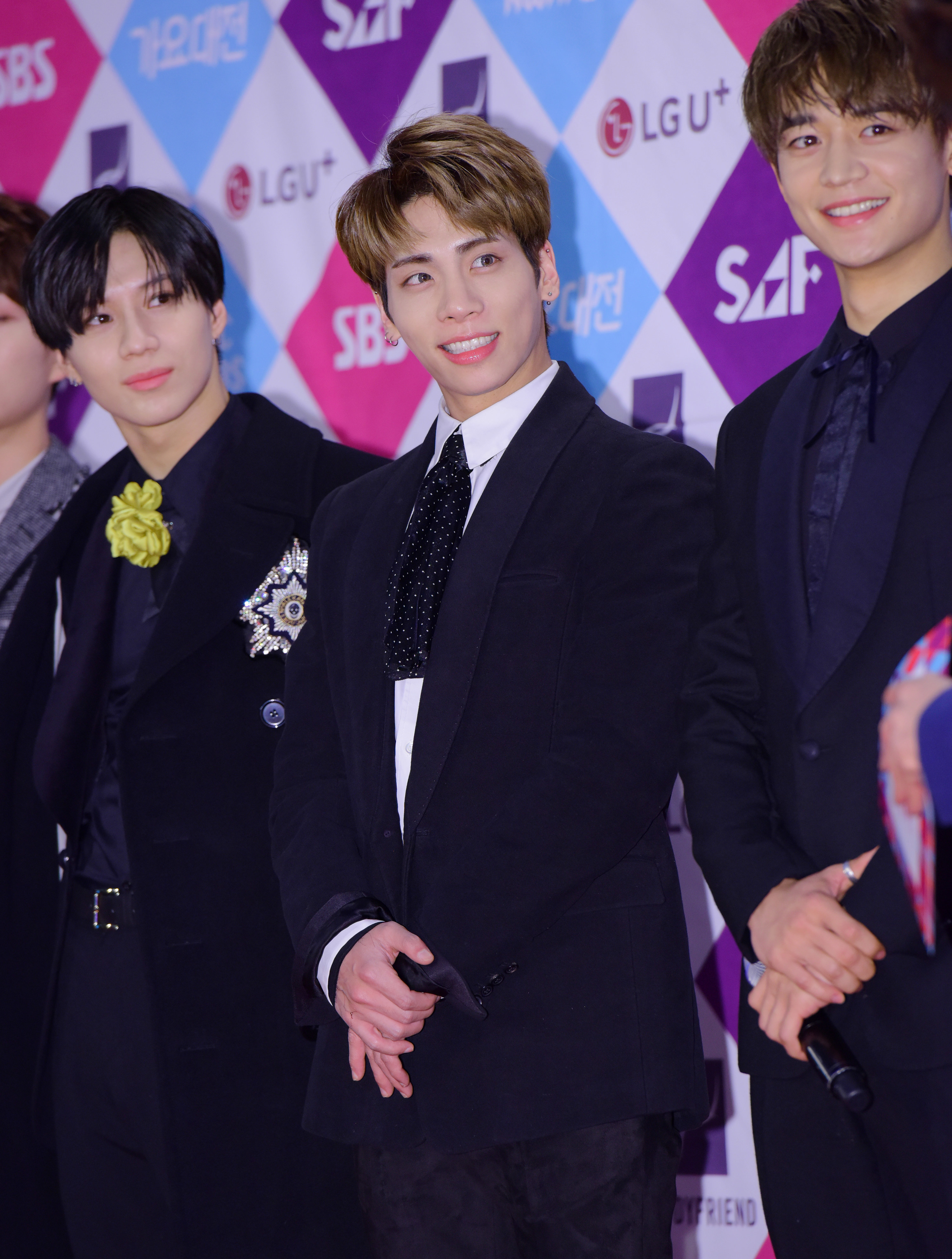 Jonghyun smiles, with band mate Taemin to his right and Minho to his left.