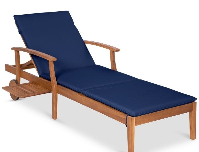 an acacia wooden lounge chair in navy with folding table attached